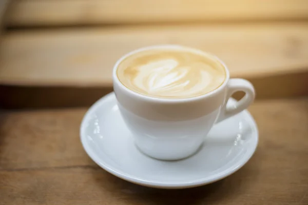 Ahşap masa arka plan üzerinde sıcak latte sanat — Stok fotoğraf