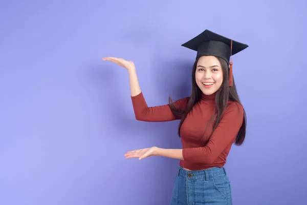 Portret Van Jonge Universiteitsstudente Met Afstudeerpet Violette Achtergrond — Stockfoto