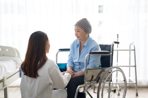 A cancer patient woman wearing head scarf after chemotherapy consulting and visiting doctor in hospital.