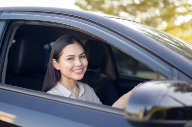 Arabasını, sigorta ve finans konseptini kullanan genç ve güzel bir kadın.