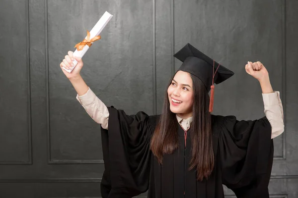 Portrait Young Woman Graduation Gown Smiling Cheering Black Background — Stock Photo, Image