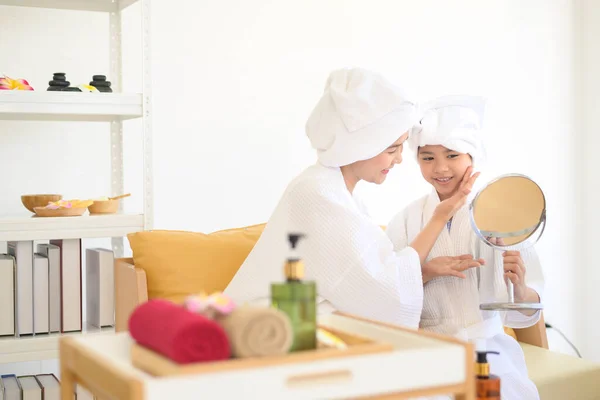 Feliz Hermosa Mamá Hija Albornoz Blanco Aplicando Crema Hidratante Cara — Foto de Stock