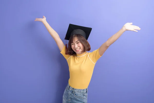 スタジオの背景に卒業キャップを着用した若いアジアの学生の肖像画 — ストック写真