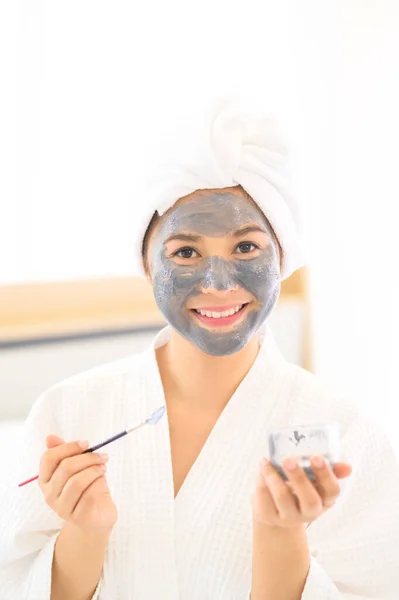 Una Hermosa Mujer Feliz Albornoz Blanco Aplicando Una Mascarilla Facial — Foto de Stock