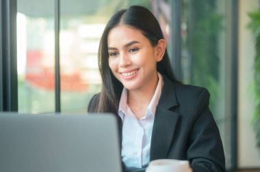 Güzel bir iş kadını bilgisayarla finansal verileri analiz ediyor, kahve dükkanında kahve içiyor. İş adamı yaşam tarzı. teknoloji kavramı .