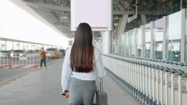 A business woman is wearing protective mask in International airport, travel under Covid-19 pandemic, safety travels, social distancing protocol, New normal travel concept