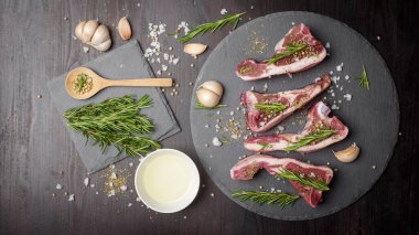 Taze çiğ et ve malzeme siyah ahşap masa üzerinde siyah taş tahtada biftek. 