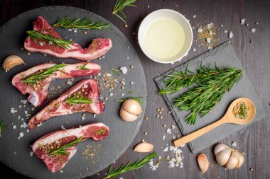 Taze çiğ et ve malzeme siyah ahşap masa üzerinde siyah taş tahtada biftek. 