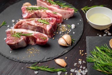 Taze çiğ et ve malzeme siyah ahşap masa üzerinde siyah taş tahtada biftek. 