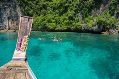 Tayland, Phi phi Adaları, Tayland 'da turistler şnorkelle yüzerken ve dalarken Tayland' ın geleneksel uzun kuyruklu teknesinden bir manzara