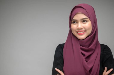 Beyaz arka plan stüdyosunda genç Müslüman bir kadının portresi.