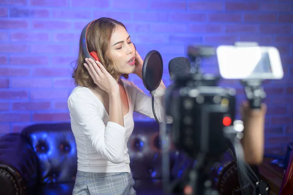 Uma Jovem Cantora Sorridente Usando Fones Ouvido Com Microfone Enquanto — Fotografia de Stock