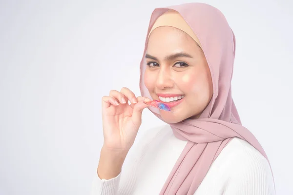 白い背景スタジオ 歯科医療 整形外科の概念を超える歯のためのカラフルな家臣を保持する若いイスラム教徒の女性 — ストック写真
