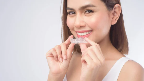 Uma Jovem Mulher Sorrindo Segurando Aparelhos Invisalign Sobre Estúdio Fundo — Fotografia de Stock