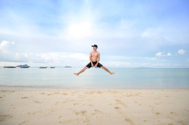 Mutlu bir adam plajda, yazda ve tatil konseptinde eğleniyor.