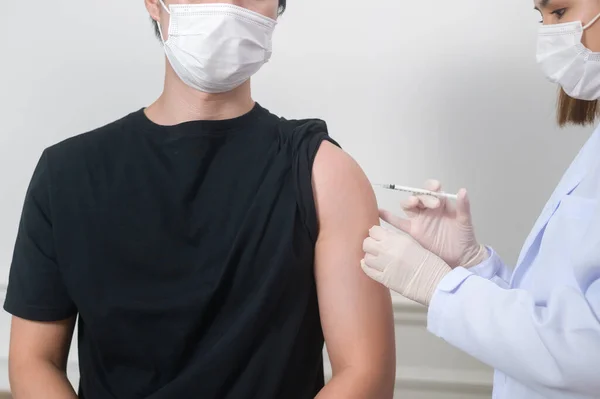 Kadın bir doktor hasta koluna kovid 19 aşısı enjekte ediyor, covid-19 aşısı ve sağlık konsepti
