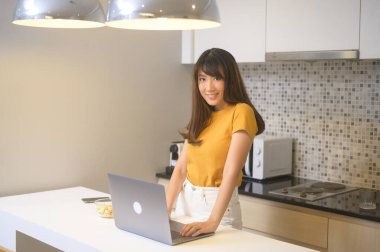 Dizüstü bilgisayarıyla çalışan ve bir fincan kahve içen genç bir kadın, yaşam tarzı ve iş konsepti.