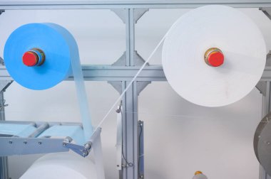 Modern fabrikada cerrahi maske, Covid-19 koruma ve tıbbi konsept üretme makinelerini kapatın..