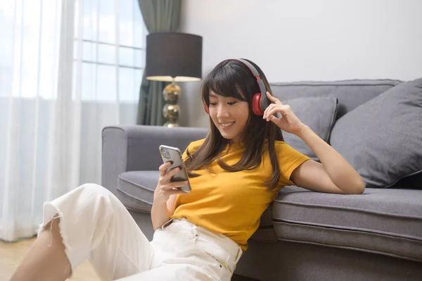 一个年轻快乐的女人 听着音乐 在家里放松 — 图库照片