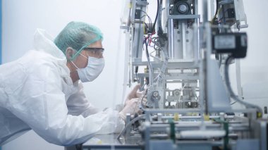 Modern fabrikada cerrahi maske üreten işçiler, Covid-19 koruma ve tıbbi konsept.