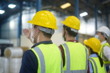 Mühendisler depoda kafalarına koruyucu kask takıyorlar. 