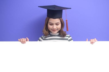 Mavi arka planda mezun olmuş genç bir kadının portresi. 