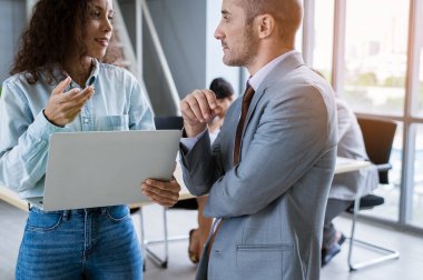 Modern ofiste tartışan ve beyin fırtınası yapan genç bir iş adamı.