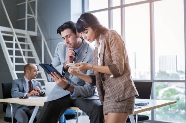 Modern ofiste tartışan ve beyin fırtınası yapan genç bir iş adamı.