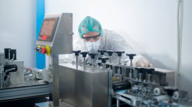 Modern fabrikada cerrahi maske üreten işçiler, Covid-19 koruma ve tıbbi konsept.