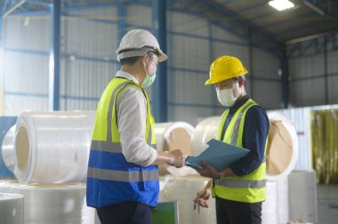 Mühendisler depoda çalışırken koruyucu maske takıyorlar. 