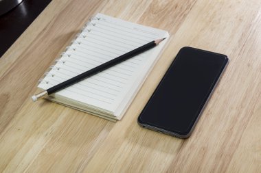 akıllı telefon, kalem ve ahşap zemin üzerine Not