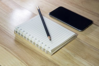 akıllı telefon, kalem ve ahşap zemin üzerine Not