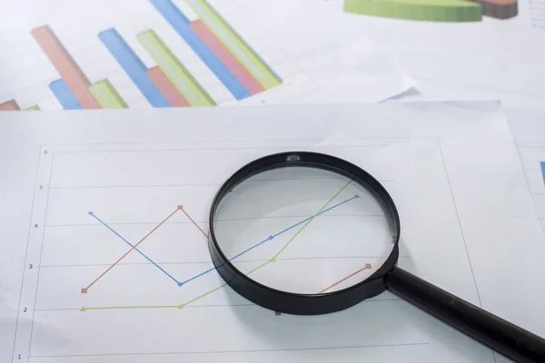 stock image Magnifying glass and documents with analytics data lying on tabl