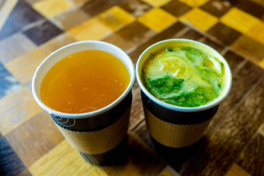 Kâğıt bardakta iki içki, limonata ve çay kafedeki masada..