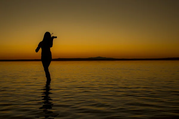 Turquía, mujer silueta violín Salt lake al atardecer —  Fotos de Stock
