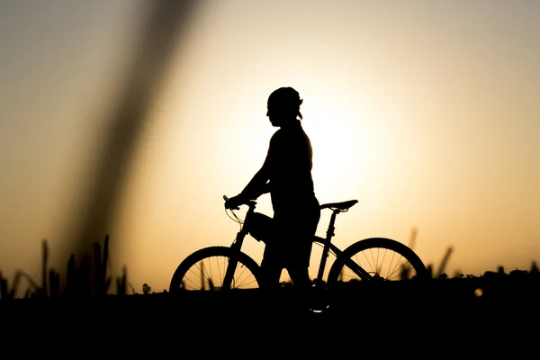 Zonsondergang en silhouet achtergrondverlichting fietsers — Stockfoto