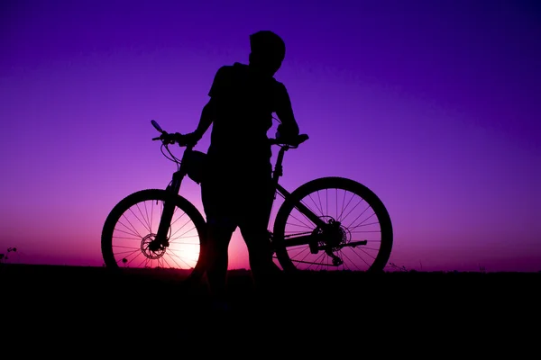 Ηλιοβασίλεμα και σιλουέτα ποδηλάτες οπίσθιου φωτισμού — Φωτογραφία Αρχείου