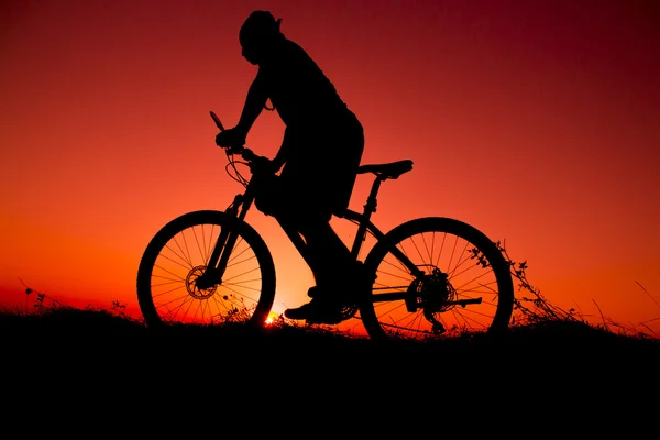 Zachód słońca i sylwetka rowerzystów podświetlenia — Zdjęcie stockowe