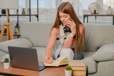 Evde dizüstü bilgisayarla ödev yapan genç kız öğrenci, çevrimiçi öğrenme, uzaktan eğitim