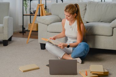 Evde dizüstü bilgisayarla ödev yapan genç kız öğrenci, çevrimiçi öğrenme, uzaktan eğitim