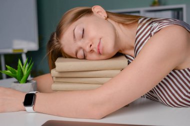 Öğrenci çok çalışıyor ve kitapların üzerinde uyuyor, serbest çalışan yorgun.