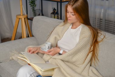 Ders kitabı okuyan ve okuyan genç bir kız öğrenci. uzaklık öğrenme kavramı