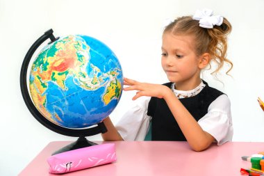 Gülümseyen güzel kızın portresi ilginç dersler sırasında öğrenme ve test yapma. Akıllı kız masada oturuyor, kameraya bakıyor ve poz veriyor. Öğrenciler arka planda çalışıyor