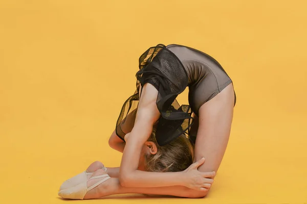 Pequena Ginasta Menina Flexível Fazendo Exercícios Diferentes Posa Fundo Amarelo — Fotografia de Stock