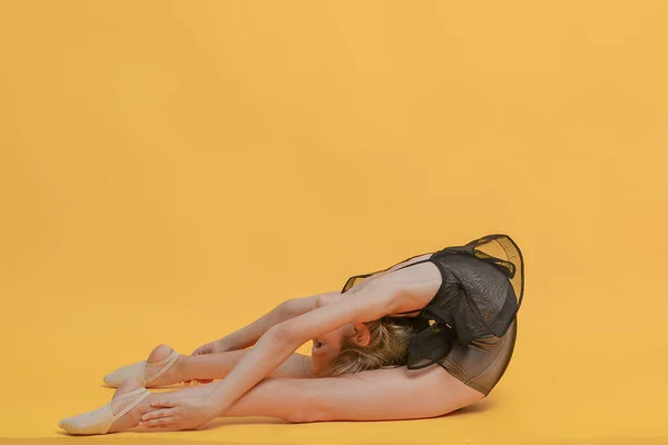 Pequena Ginasta Menina Flexível Fazendo Exercícios Diferentes Posa Fundo Amarelo — Fotografia de Stock