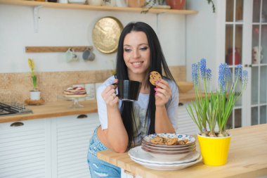 Çekici genç kadın mutfağında çay içiyor.