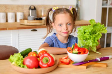 Mutfakta sebzeli ve meyveli küçük kız.