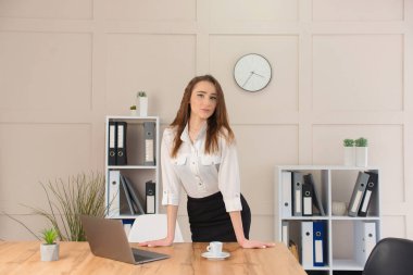 Güzel genç iş kadını ofisteki bilgisayarın başında çalışıyor. Bağımsız uzaktan çalışma