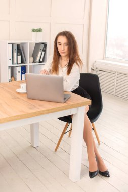 Güzel genç iş kadını ofisteki bilgisayarın başında çalışıyor. Bağımsız uzaktan çalışma