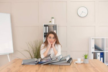 Kadın sekreter büroda belgelerle çalışıyor. Bir iş kadını için çok iş var.